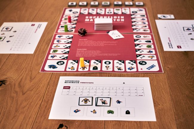 Exemplarische Spielsituation des SMM: Spielbrett mit Figuren, Ereigniskarten und Punktetafel.